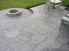 an outdoor fire pit surrounded by chairs and tables