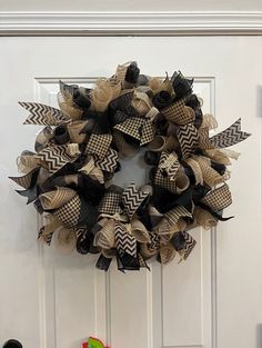 a black and tan wreath on a white door