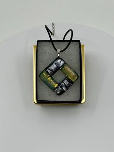 Beautiful dichroic glass pendant, handmade by me, Jason Hoffman, here in Eau Claire, Wisconsin. This stunning, one-of-a-kind piece measures 2" in height, and 2" in width, is topped with a sterling silver plated bail, and comes with a 16" black leather cord upon purchase. Iridescent Glass Necklaces As Gifts, Iridescent Glass Jewelry As Gift, Iridescent Glass Jewelry Gift, Iridescent Glass Jewelry For Gifts, Unique Rectangular Glass Jewelry, Iridescent Large Pendant Jewelry Gift, Handmade Glass Jewelry With Rectangular Pendant, Handmade Glass Rectangular Pendant Jewelry, Glass Necklaces With Rectangular Pendant For Gift