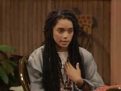 a woman with long dreadlocks sitting at a table