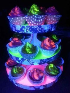 three tiered cupcake display with colorful frosting on it's top and bottom