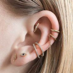 a woman wearing three different types of ear piercings