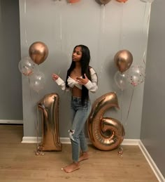 a woman standing in front of balloons and the number six