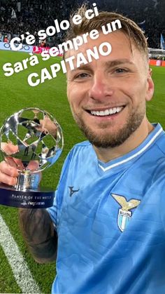 a man holding up a trophy on top of a soccer field with the caption's name in spanish