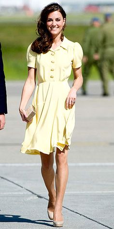 a woman in a yellow dress is walking down the street