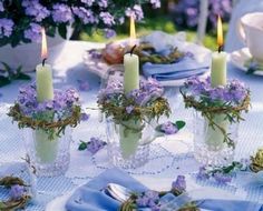 four candles with flowers in them on a table