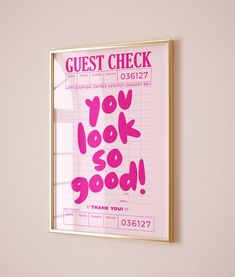 a pink poster with the words guest check hanging on a wall next to a window