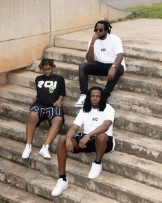 three young men sitting on the steps outside