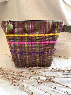 a small purse sitting on top of a white table next to dry grass and twigs