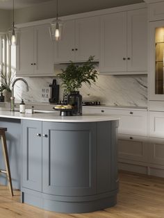 a kitchen with an island and stools in the center, surrounded by white cabinets