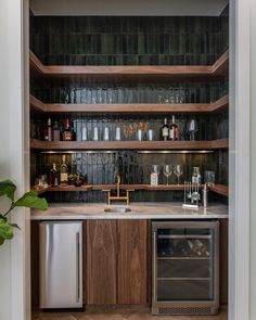 a kitchen with an oven, dishwasher and wine glasses on the shelves above it