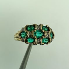 * Designer 14K Yellow Gold Oval Emerald Diamond Accented Dome Cocktail Ring * Ring size: 7.0 * Top of ring measures 3/8" x 5/8" * Height: 1/4" * Band width: 2.08 mm * Seven oval Emeralds measure approximately 4.3 mm x 2.7 mm each * Diamonds measure approximately 1.25 mm each * Ring weight: 3.3 tgw * Marked: 10K * MAKERS MARK * CR3HD163 * Ring can be resized for an additional fee. * Condition: As pictured * G3365    Exported By ExportYourStore :) Oval Yellow Gold Emerald Ring With Multi-stone, Oval Yellow Gold Emerald Ring With Multiple Stones, Oval Multi-stone Yellow Gold Rings, Green Multi-stone Oval Diamond Ring, Oval Yellow Gold Multi-stone Rings, Green Oval Dome Ring For Formal Occasions, Green Oval Multi-stone Diamond Ring, Oval Green Multi-stone Diamond Ring, Oval Emerald Ring Stamped 14k