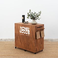 a wooden box with some items on top of it and a potted plant in the corner