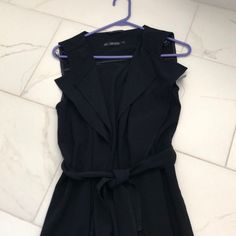 Small Black Sleeveless Wrap For Any Dressy Or Casual Occasion. Ruffled Detail And Tie Belt For Form Fitting Around The Waist. Nice Thick Quality Material- Knee Length (Approx 32 In Long) Can Dress Up With Dress Or Skirt Or Dress It Down And Pair It With Leggings/Jeans Machine Wash- Gentle Cycle Was Pregnant And No Longer Fits Me- Never Worn! Black Formal Summer Vest, Black Summer Formal Vest, Elegant Black Vest For Spring, Black Sleeveless Vest For Day Out, Black Vest For Spring Day Out, Black Vest For Day Out In Spring, Chic Black Vest For Day Out, Zara Vest For Summer Workwear, Chic Black Vest For Spring