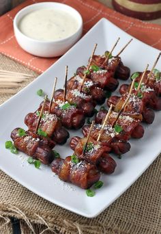 small skewered meats are on a plate with toothpicks