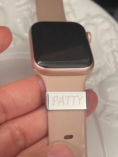 a person holding an apple watch in their left hand with the word patty on it