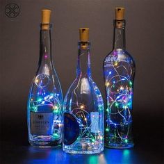 three bottles with lights in them sitting next to each other