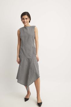 This midi dress features a flowy fit with an asymmetrical hemline and a non-stretchy material. It has a sleeveless design and a round neck. Our midi dress has adjustable backstraps and a concealed side zipper closure. Modern A-line Maxi Dress For Spring, Knee-length Asymmetrical Dress For Spring Workwear, Chic Spring Dress With Handkerchief Hem, Modern Black Sleeveless Asymmetrical Dress, Chic High Low Dress With Asymmetrical Hem For Spring, Asymmetrical Summer Maxi Dress For Work, Casual Asymmetrical Dress With Asymmetrical Hem For Work, Asymmetrical Summer Work Dress, Asymmetrical Summer Dress For Work