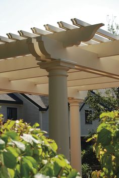 a white pergola on the side of a house