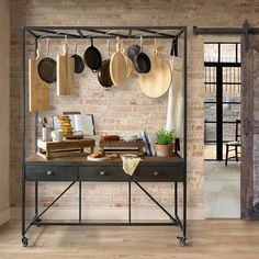 a kitchen with pots and pans hanging on the wall next to an iron table