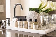 a bathroom counter with bottles and soaps on it