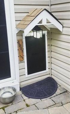 a dog house that is on the side of a building with a bowl in front of it