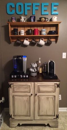 a coffee bar with two shelves above it and cups on the top, below which is a sign that says coffee