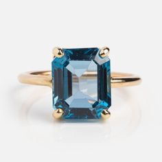 an emerald cut blue topazte ring in yellow gold