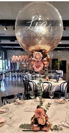 the table is set up for an event with large balloons and flowers on top of it