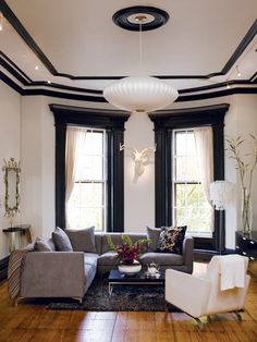 a living room filled with furniture next to two windows