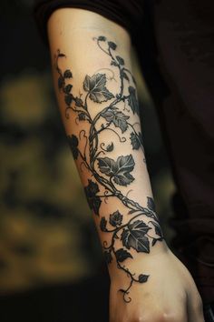 a woman's arm with vines and leaves on it