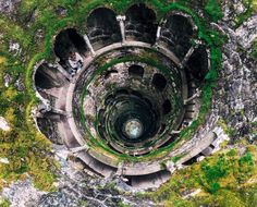 an aerial view of the inside of a stone structure with moss growing on it's sides