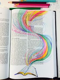 an open book with colored pencils on it