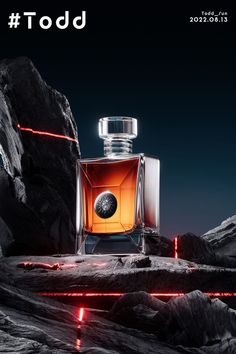 a bottle of perfume sitting on top of a rocky mountain next to a red light