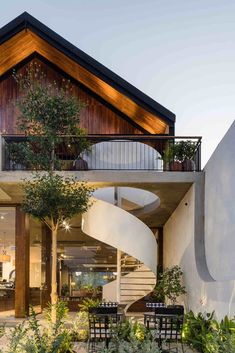 a house with a spiral staircase leading up to the second floor and an outdoor dining area