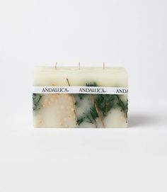 an image of a candle that is made out of white and green soap with pine needles on it