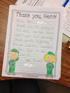 a thank note with two children dressed in green standing next to each other on a wooden table