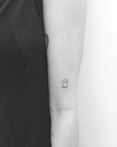 black and white photo of a woman's arm with a small padlock tattoo