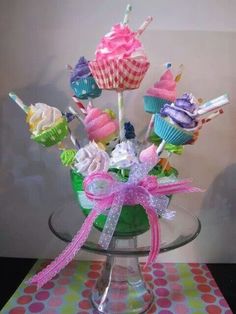 a vase filled with cupcakes on top of a table