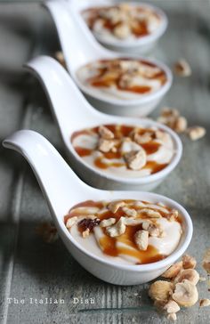 three white spoons filled with food on top of a table