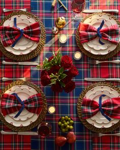 the table is set with red, white and blue plaid place settings for four people