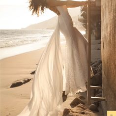 a woman in white dress standing on the beach