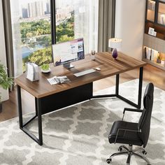 an office desk with a computer on it in front of a window overlooking the city