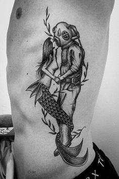 a man with a tattoo on his stomach is holding a fish in the shape of a skull