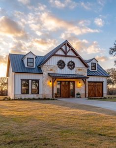 a white and brown house sitting on top of a lush green field