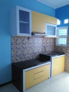 a kitchen with blue walls and yellow cabinets