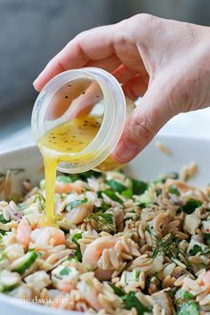 someone pouring dressing into a white bowl filled with rice and vegetables, including broccoli