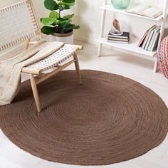 a chair sitting on top of a rug next to a white shelf filled with books