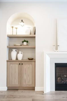 a living room filled with furniture and a fire place in front of a white fireplace