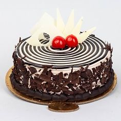 a chocolate cake with two cherries on top